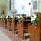 Dekorierte Bankreihen in einer Kirche mit einer Komposition aus Lilien